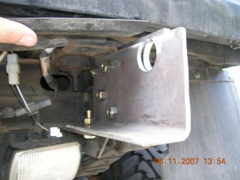 1996 Ford Bronco - A custom bracket is attached to the vehicle's frame, with wiring and a headlight visible.