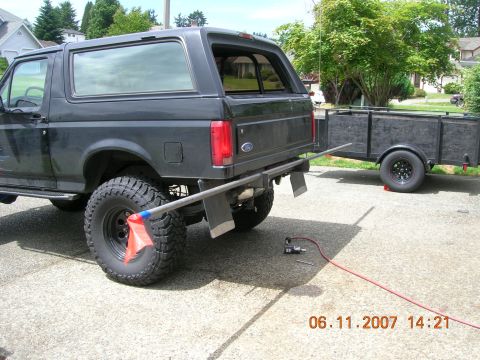 1996 Ford Bronco - Rear view of a 1996 Ford Bronco, hitched to a trailer, with an air tool and hose nearby.