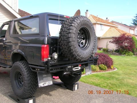 1996 Ford Bronco - Rear view of a black Ford Bronco, modified with an aftermarket bumper and spare tire.