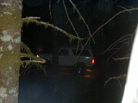 1994 Ford Explorer - A white SUV is parked at night, with its taillight illuminated and reflections visible on the wet ground.