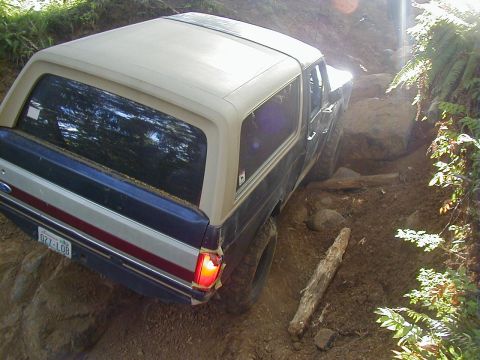 1994 Ford Explorer - Ford Bronco tackling an off-road obstacle course on a dirt path.