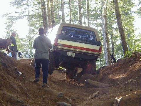 1994 Ford Explorer - Ford Bronco tackling a challenging off-road course with spectators present.