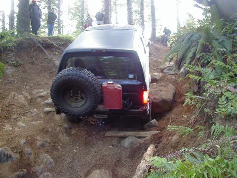 1994 Ford Explorer - A black 1994 Ford Explorer navigates a challenging, rocky off-road trail.