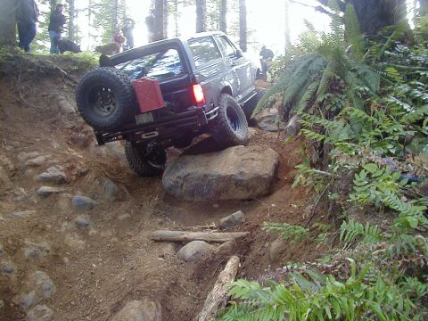 1994 Ford Explorer - Ford Bronco tackling a challenging off-road obstacle course with steep inclines and large rocks.