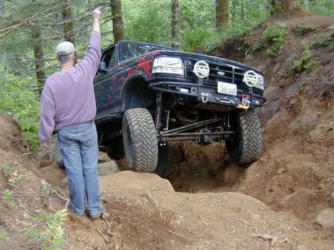 1994 Ford Explorer - A modified 1994 Ford Explorer navigates a steep, rocky trail with a person directing.