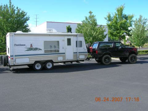 1996 Ford Bronco - A modified Ford Bronco tows a Dutchmen travel trailer in a parking lot on a sunny day.