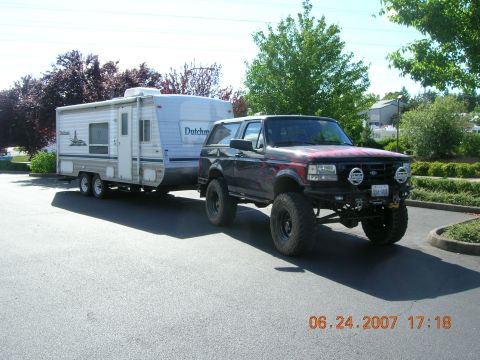 1996 Ford Bronco - A modified 1996 Ford Bronco, equipped with large off-road tires and custom paint, is shown towing a Dutchmen travel trailer.