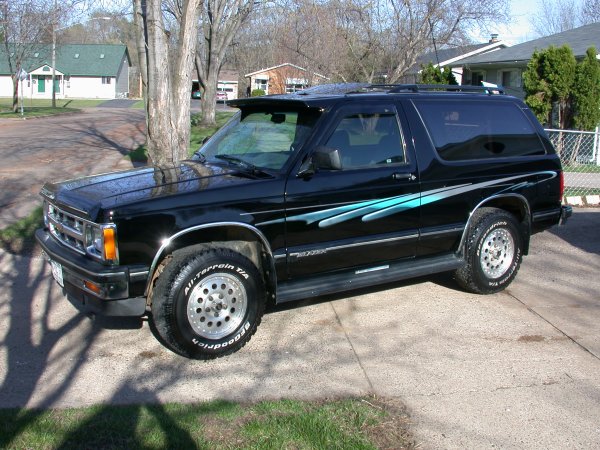 Black SUV with blue graphics on the side, parked on a concrete driveway