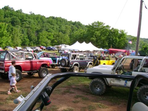 1969 Ford Bronco - Several Ford Broncos are gathered at an outdoor event with a large tent in the background.