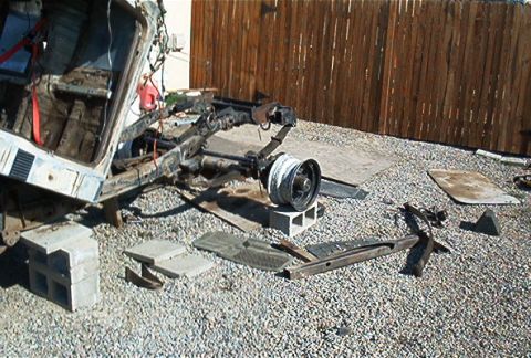 1982 Toyota 4Runner - The chassis and suspension of a vehicle are visible, with one wheel resting on cinder blocks.