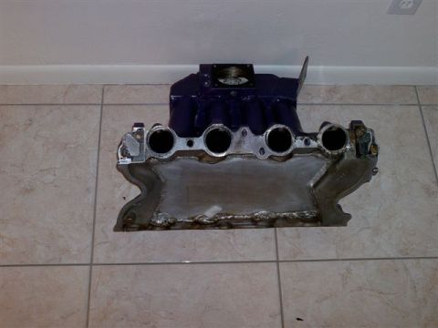 1988 Ford Bronco - An intake manifold with a purple top and silver base is shown on a tiled surface.