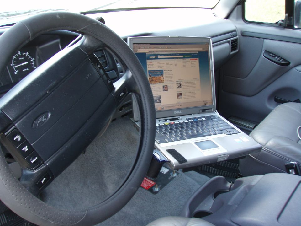Steering wheel and dashboard of a 1990s Ford truck with a Dell laptop mounted