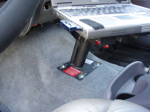 1996 Ford Bronco - A laptop mount is installed on the floor of a vehicle, a prominent red warning label.