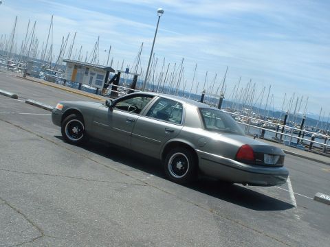 2000 Ford Crown Victoria - A gray 2000 Ford Crown Victoria is parked at a marina on a sunny day.