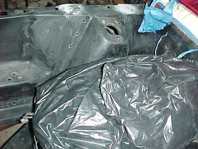 Engine bay covered in plastic sheeting, some blue plastic visible
