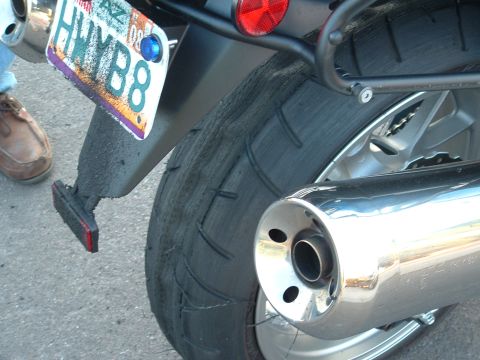 2007 Kawasaki Ninja - The worn rear tire of a motorcycle is visible, along with its license plate.