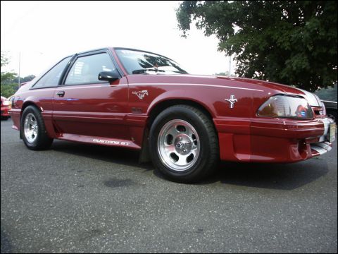 2001 Mercury Grand Marquis - Red 1987 Ford Mustang GT parked on asphalt, showing its side profile and front quarter.