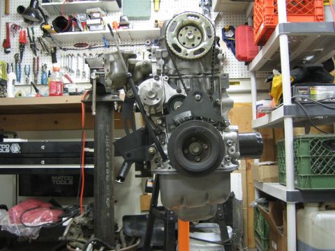 1987 Suzuki Samurai - Engine assembly in a cluttered garage setting with tools and shelves visible.