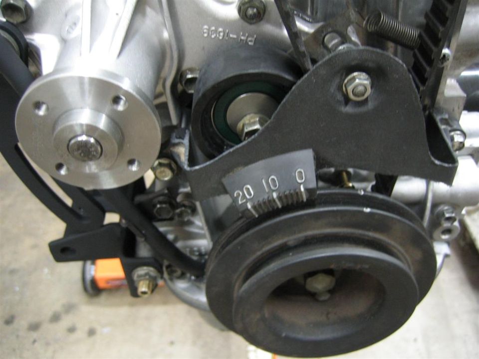 Engine timing belt tensioner adjustment bracket with degree markings