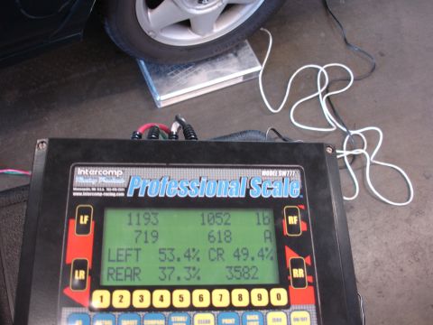 1993 Ford Taurus - A car's weight is being measured on a professional scale, showing distribution across the wheels.