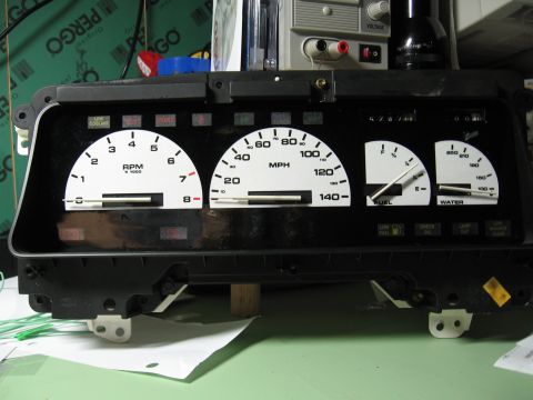 1992 Ford Taurus - A car's instrument cluster, a tachometer, speedometer, fuel gauge, and water temperature gauge, is shown removed from the vehicle.