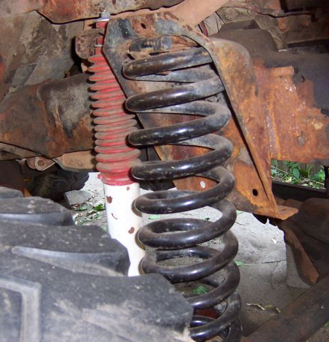 1978 Ford Bronco - Close-up of a vehicle's front suspension system, showing a coil spring and shock absorber.