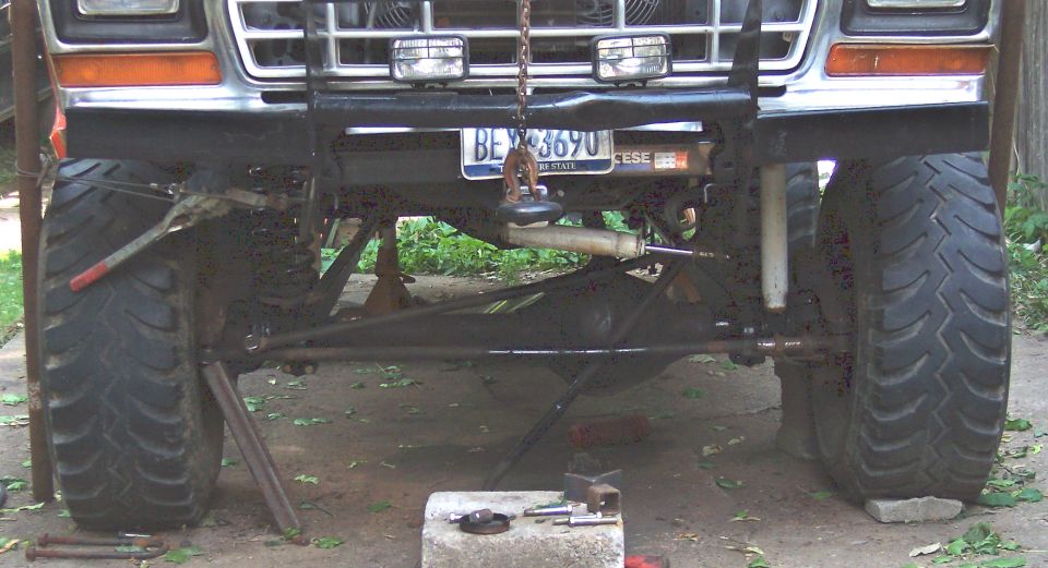 Front suspension and large tires of a lifted 1978 Ford Bronco undergoing work