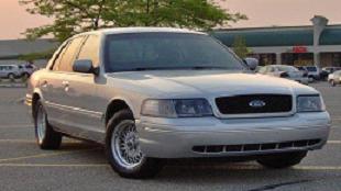 2002 Ford Crown Victoria - Silver 2002 Ford Crown Victoria in a parking lot during the day.