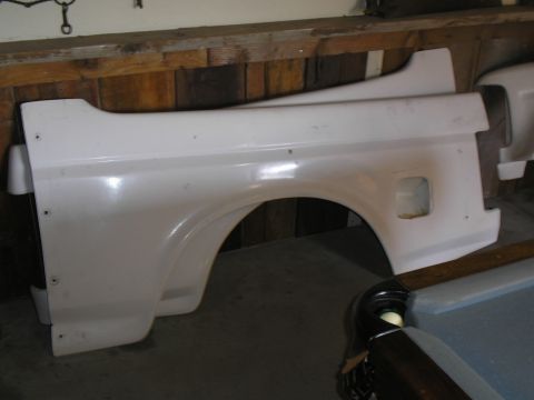 1990 Ford Bronco - A white fiberglass fender flare is shown, likely an aftermarket part for a truck.