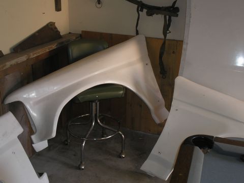 1990 Ford Bronco - A white fiberglass fender is shown, possibly for a custom build, with a stool underneath.