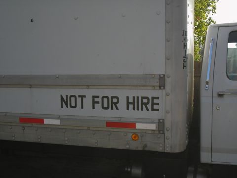 1999 Ford F-800 - A truck is parked next to a white box trailer that has "NOT FOR HIRE" printed on its side.