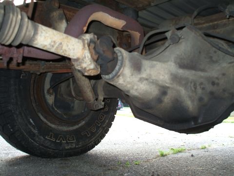 1994 Ford Bronco - Undercarriage view of a vehicle's rear differential and driveshaft, with visible rust and wear.