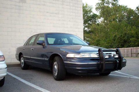 1996 Ford Crown Victoria - Dark blue 1996 Ford Crown Victoria sedan parked outside, equipped with a front pushbar.