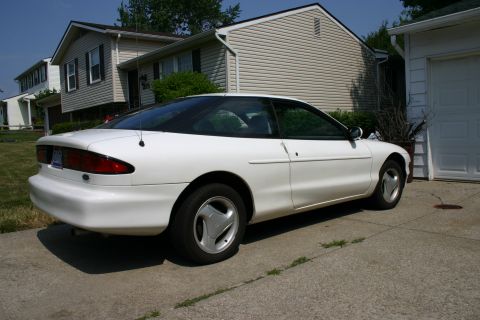 1997 Ford Probe - A white 1997 Ford Probe is parked on a concrete driveway in front of a residential garage.
