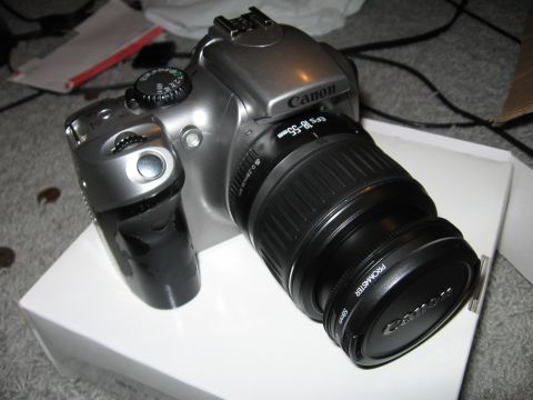 1997 Ford Probe - A silver Canon DSLR camera with a black lens is placed on a white box.