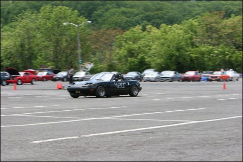 2001 Mercury Grand Marquis - A black convertible sports car participates in an autocross event on a paved lot with trees in the background.