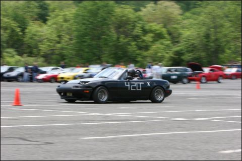 2001 Mercury Grand Marquis - A black convertible sports car, marked with '420 X', navigates an autocross course with other vehicles in the background.