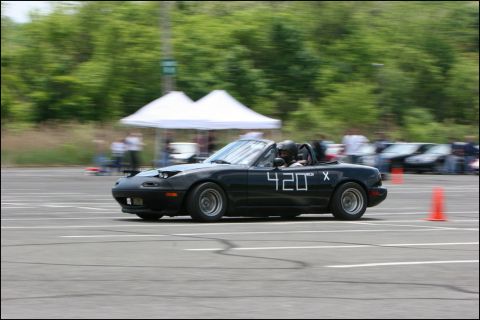 2001 Mercury Grand Marquis - A black convertible with racing numbers navigates a course with spectators and other vehicles present.