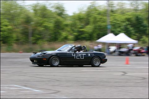 2001 Mercury Grand Marquis - A black convertible sports car with racing numbers navigates an autocross course.