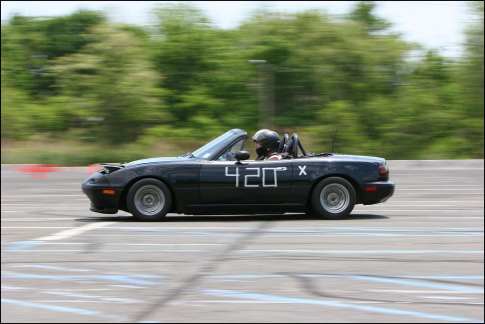 Black convertible with number 420 on the side driving on a track
