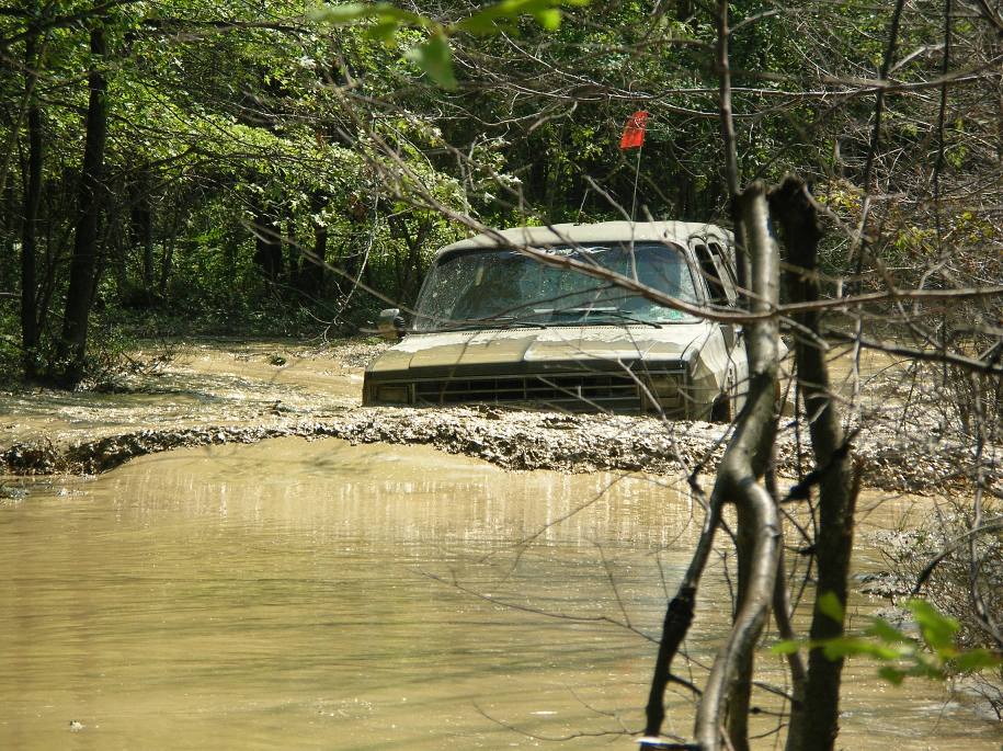 Light-colored pickup truck stuck in mud, front view