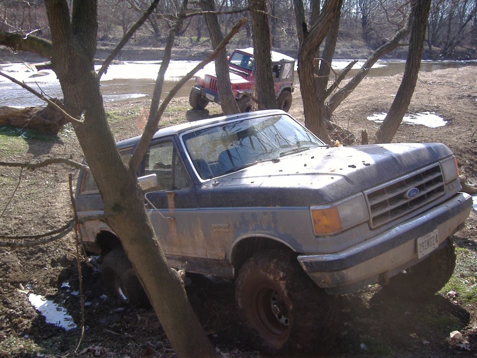 Ford Bronco stuck in mud with a Jeep in the background