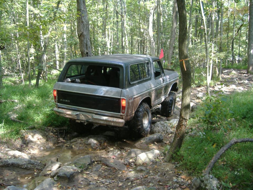 1978 Ford Bronco off-roading on a rocky trail, rear view