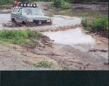 1989 Ford Bronco - This Ford Bronco appears to be from the late 1980s, stuck in a muddy off-road course.