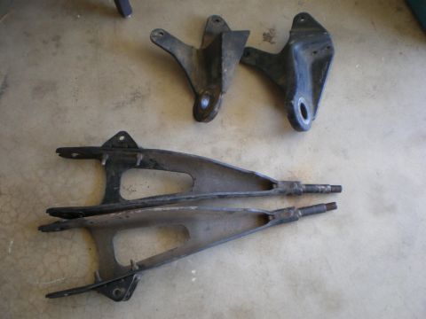 1978 Ford F-250 - Set of used suspension control arms and brackets laid out on a concrete surface.