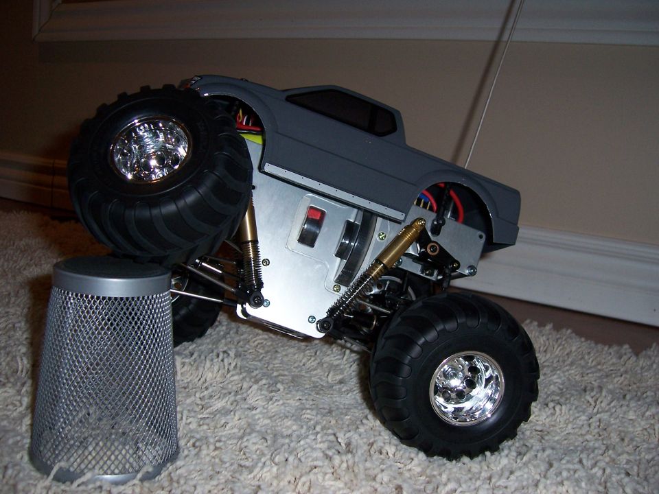 Remote control monster truck with large tires, silver chassis, and grey body