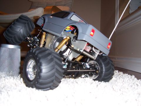 1996 Ford Bronco - A gray remote control monster truck is shown from a three-quarter front angle on a carpeted surface.
