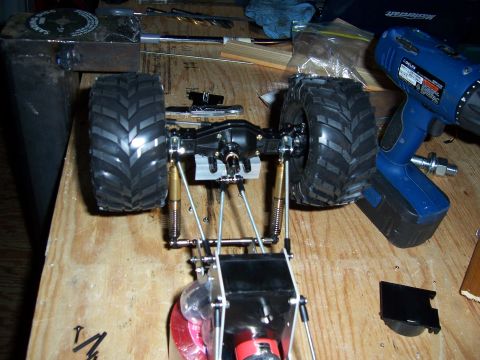 1996 Ford Bronco - The chassis and suspension of a remote control car are shown, with a power drill nearby.