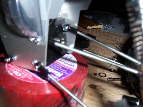 1996 Ford Bronco - Detail of mechanical components and fasteners, including a roll of red tape, on a workbench.
