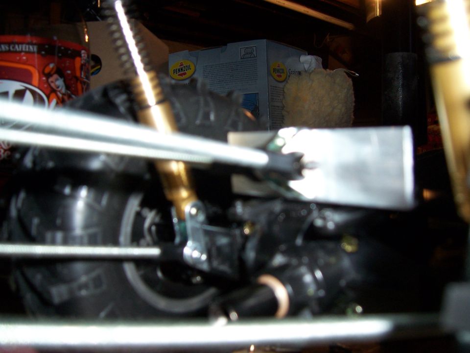 Close-up of a black suspension and wheel assembly with gold shock absorber